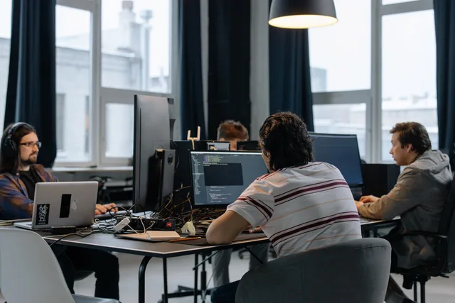 Team of developers working together on computers in a modern tech office. Kompetensförsörjning i svenska bolag: från behov till bemanning